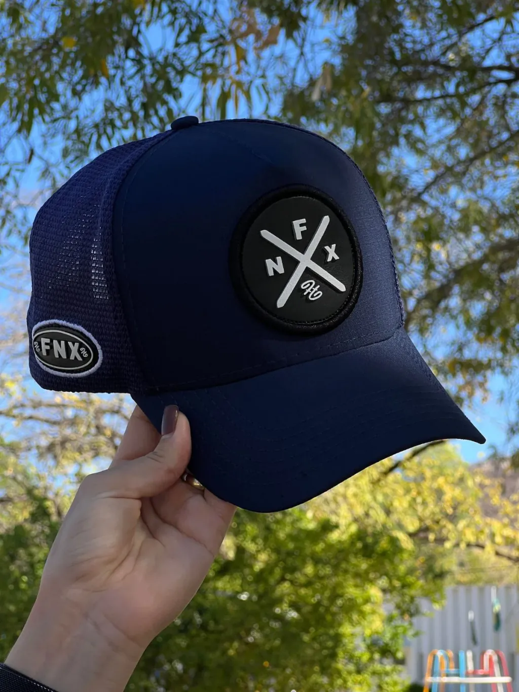 Boné trucker azul-marinho personalizado com patch redondo emborrachado NFX. Modelo resistente e estiloso da Fênix Personalizados.
