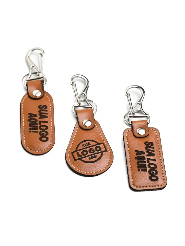 Chaveiros de couro personalizados com mosquetão e logo gravado. Brindes sob medida da Fênix Personalizados.